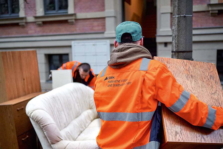 Mitarbeiter trägt Sperrmüll.