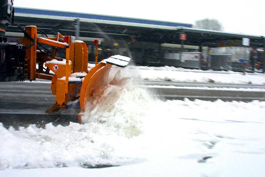 Ein Schneeschieber scheibt Schnee.