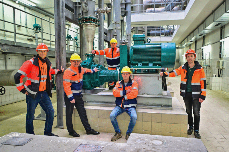 Mitarbeiter stehen vor Pumpe.