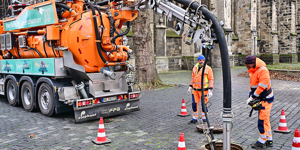 Mitarbeiter arbeiten mit dem Spülfahrzeug.