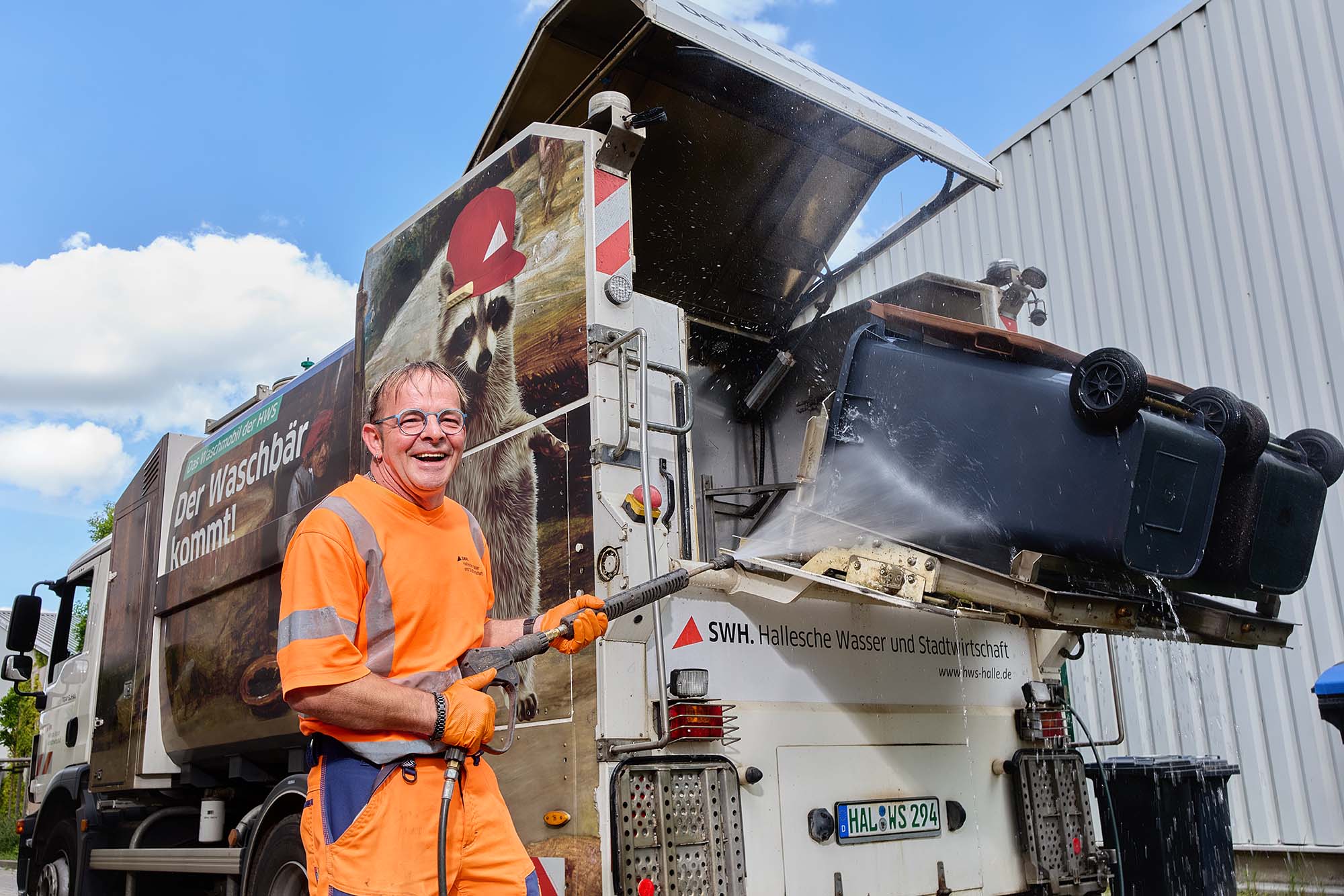 Mitarbeiter wäscht Tonne.