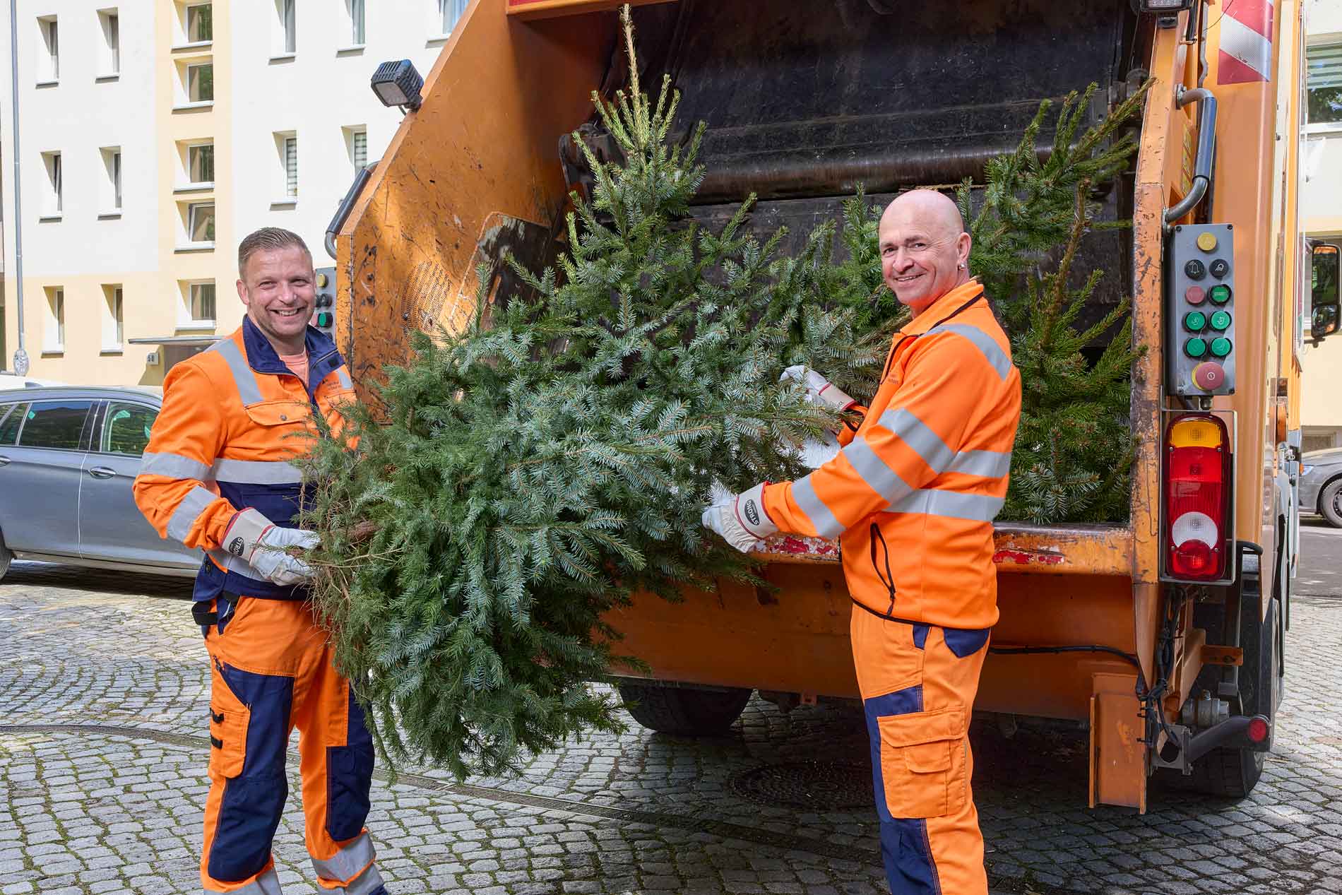 Mitarbeiter bei der Entsorgung von Weihnachtsbäumen.