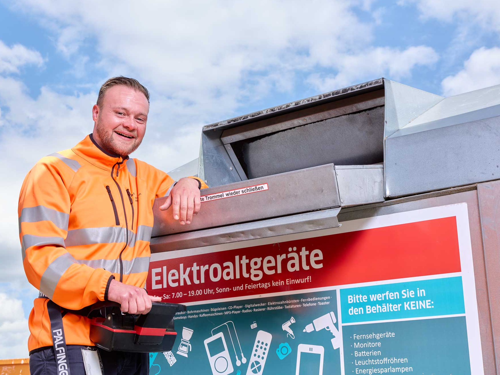 Mitarbeiter steht vor Elektroaltgerätecontainer.
