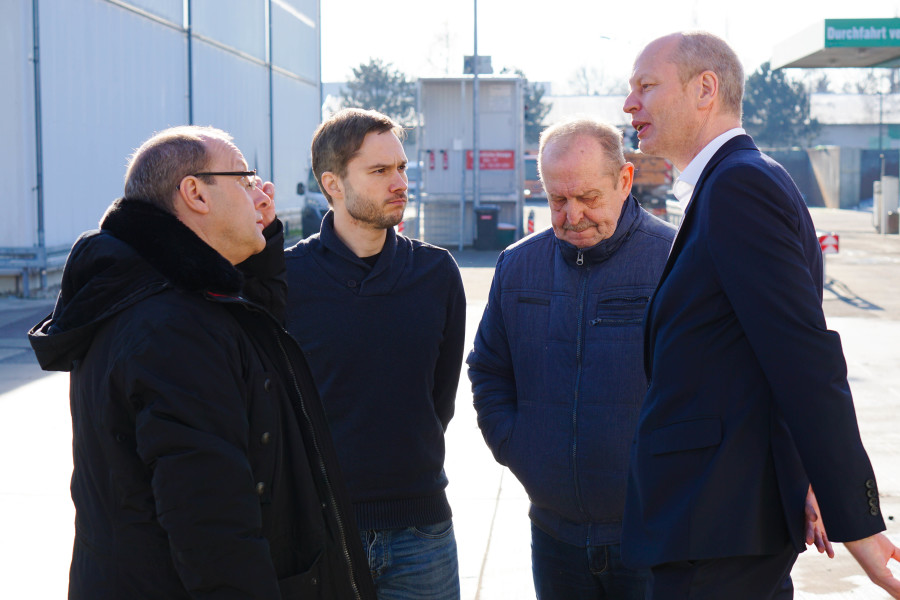 Vier Männer stehen zum Gespräch auf dem Wertstoffmarkt der Halleschen Wasser und Stadtwirtschaft