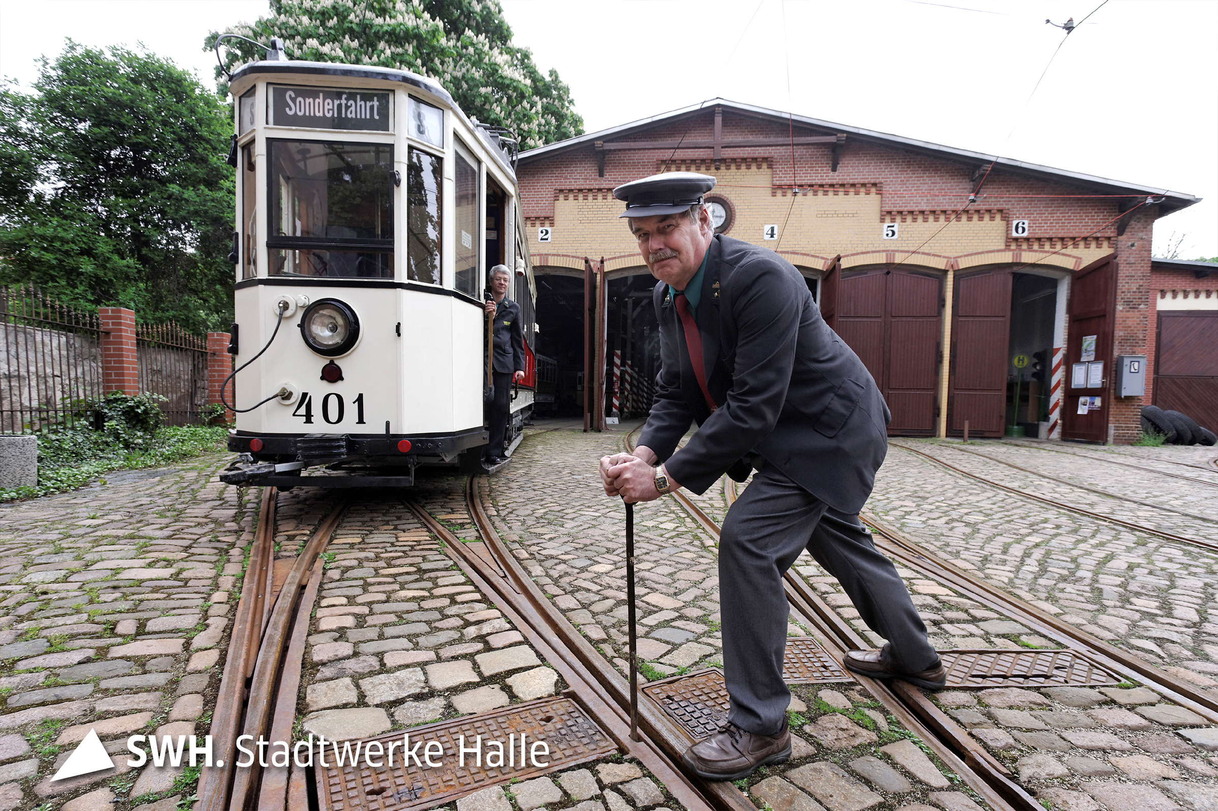 Ein Mann stellt die Weiche für eine historische Straßenbahn.