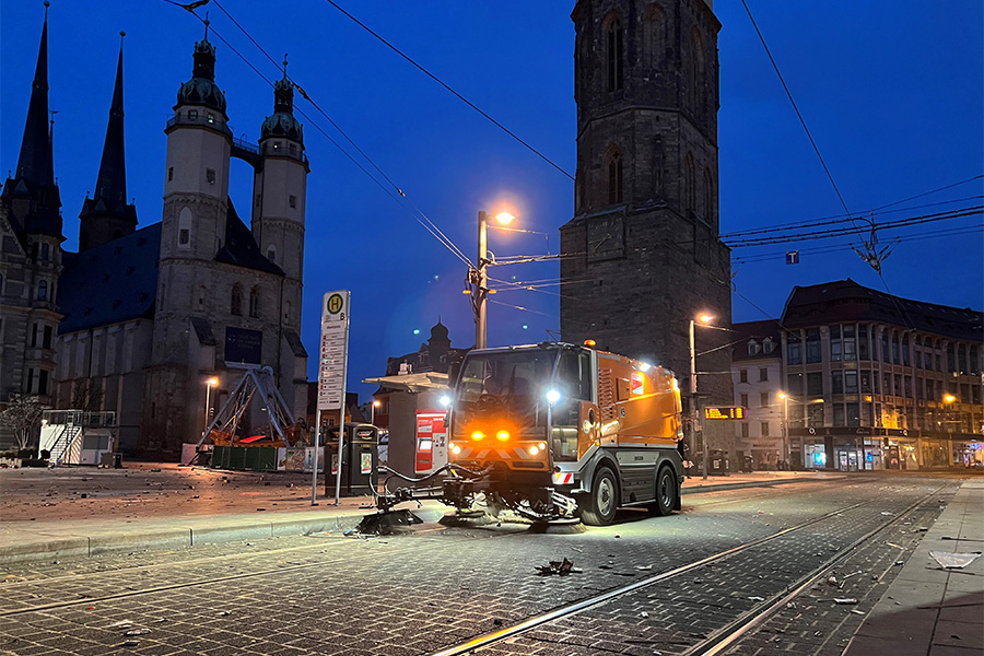Eine Kehrmaschine sammelt den Silvestermüll zwischen den Straßenbahngleisen auf dem Marktplatz in Halle ein.