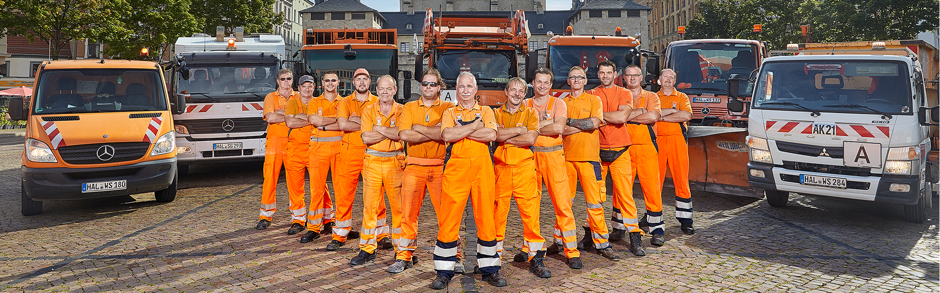 Mitarbeiter mit ihren Einsatzfahrzeugen.